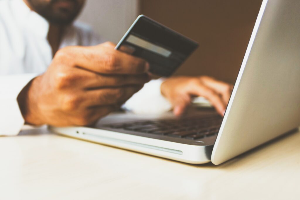 Homme achetant en ligne sur un ordinateur avec une carte de crédit