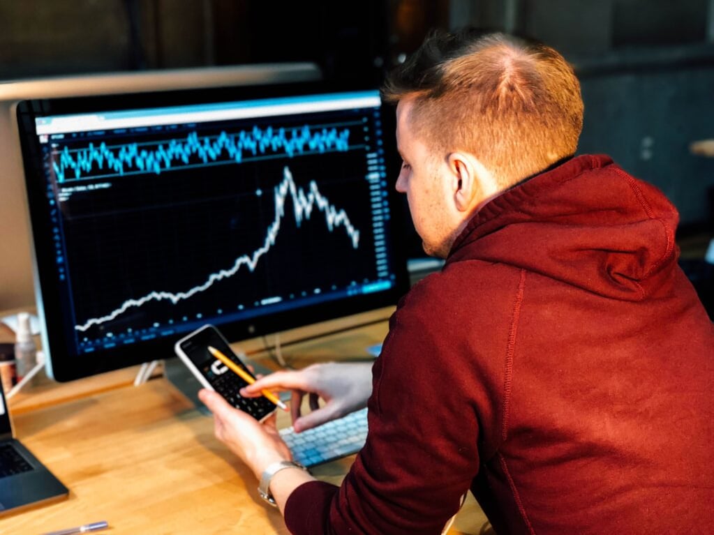 Boy with a smartphone and a pc with chart